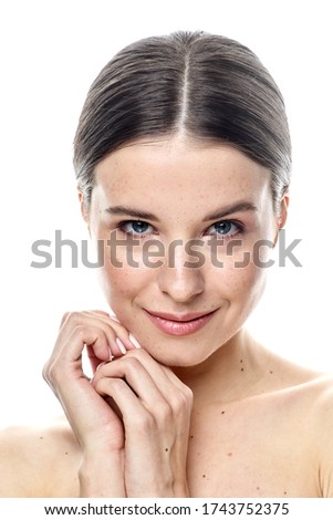 A close-up portrait of a girl with freckles and clear skin. Light blue eyes. The girl has different emotions, she looks at the camera. Isolated on a white background and there is a place where you can