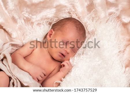picture of a newborn baby sleeping on a blanket rolled.
