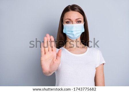 Photo of pretty serious lady keep social distance avoid people contacting hospital examination raise arm stand far away wear protect face mask t-shirt isolated grey color background Royalty-Free Stock Photo #1743775682
