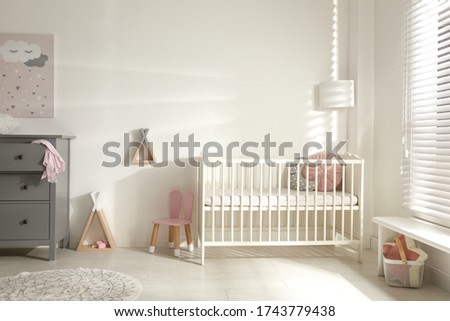 Cute baby room interior with crib and decor elements Royalty-Free Stock Photo #1743779438