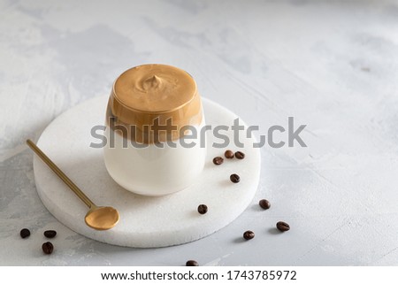 Dalgona coffee. Iced fluffy creamy whipped trendy drink with coffee foam and milk. Trendy drink during Covid-19 city lock down and self quarantine, stay at home concept. Side view