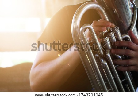 Selectable focus, close-up shots of male musicians Who are playing the euphonium blower in the selected marching band.