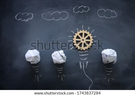 Education concept image. Creative idea and innovation. Wooden gears light bulb metaphor over blackboard