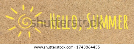 Hello summer text Sun sign drawn on sand. Creative top view Copy space Banner.