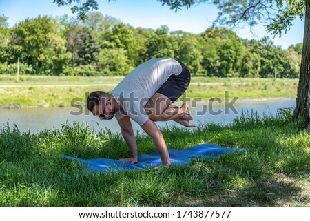 Young athletic man doing yoga on a mat with natural light.