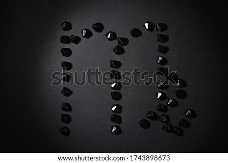 Symbol of the zodiac sign Virgo made by black stones on a black background. Low dark key. Vignetting lighting. Horoscope Theme
