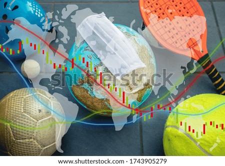 Photo of different sport balls and an earth globe with a face mask. On top different layers off stock market graph.