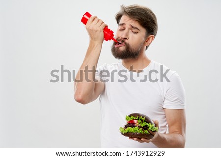 man with red jar in hand ketchup and hamburger