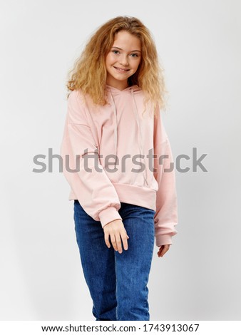 Beautiful little girl in jeans and a pink sweater