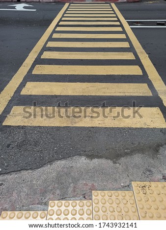Pedestrian crosswalk with yellow and lines on the asphalt