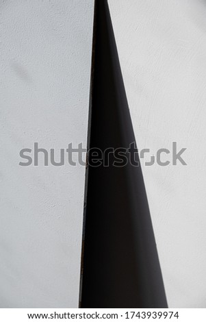 black shadow in the form of a triangle on a concrete wall. background, abstraction. Gray.