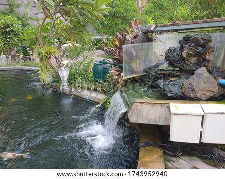 a stacked stone waterfall on the edge of the fish pond to allow water to flow into the fish pond