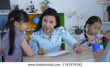 The teacher is talking to the children in the classroom. Royalty-Free Stock Photo #1743974582