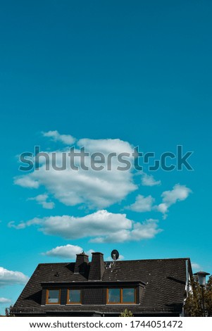 house front view with blue sky and clouds