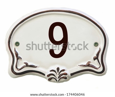 White ceramic decorated tile showing the number 9 