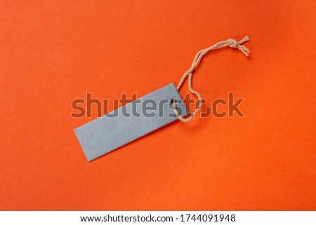 Blank tag tied with string. Price tag, gift tag, sale tag, address label isolated on green background.