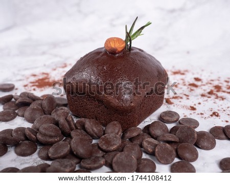 chocolate cake with almond on top placed on white background.