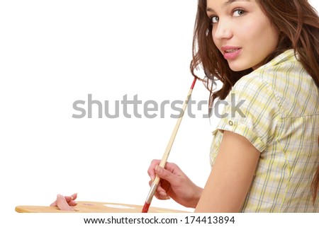 A beautiful girl with a brush and a palette, sittting isolated on white
