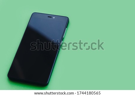 Smartphone lying on green background