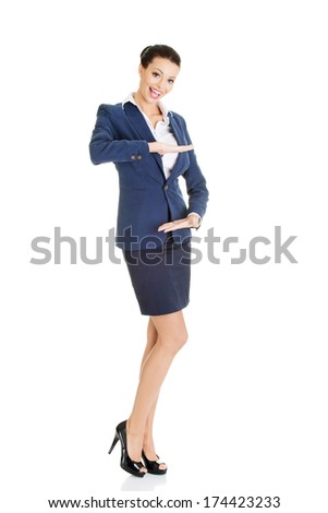 Happy young business woman showing copy space on her palm, isolated on white 
