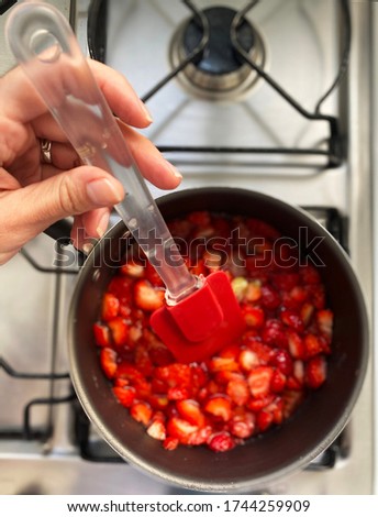 Selective focus. Making a strawberry jam. Boil strawberries in the pan. Texture fruit, strawberry jelly. Do it yourself process, homemade food. 