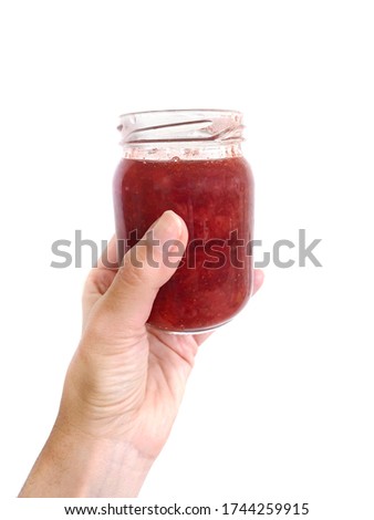 Homemade strawberry jam in a glass jar over white background. Texture fruit, strawberry jelly. Do it yourself process, homemade food. 