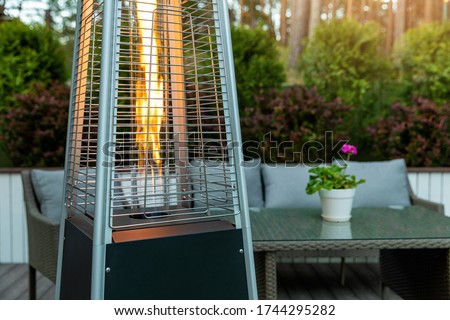 outdoor gas pyramid heater working on terrace Royalty-Free Stock Photo #1744295282