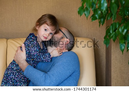 Father kissing his cute little daughter. Girl hugging her father.