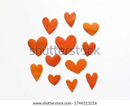 Hearts are cut from citrus crusts on a white background