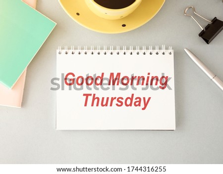 Good Morning Thursday. White card with text Good Morning Thursday on wooden table, with red ribbon