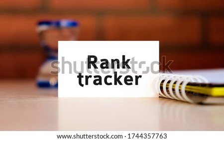 Rank tracker - seo text in white sheet with notepad and hourglass