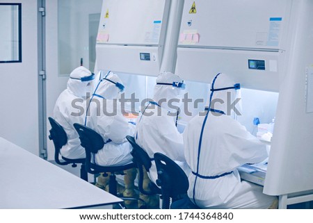 A team of Virologists work in laboratory, creating coronavirus vaccine.A group of scientists conducts research in a scientific laboratory using advanced technology. COVID-19. COVID Coronavirus Royalty-Free Stock Photo #1744364840