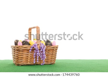 Basket full with colorful and chocolate easter eggs in the grass