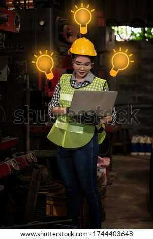 engineer woman standing with computer laptop in workshop in factory.