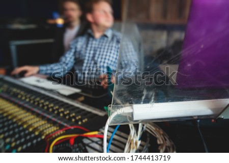 Sound editor engineer working at studio with mixing panel, mixing music and sound, stage sound mixer, boutique recording studio, working during concert performance recording, broadcasting studio