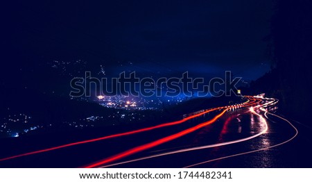A Night Photograph Of Car Light Trails On The Road After Rain.
