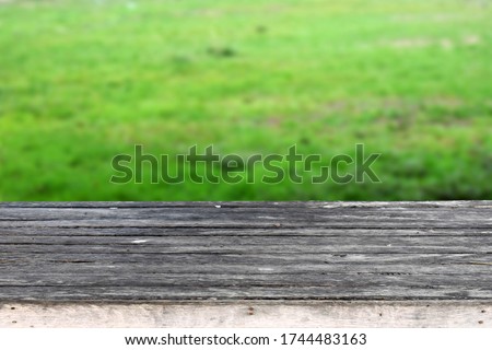 Old gray wooden board on a blurred green background is perfect for design work.