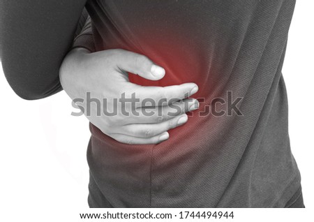 The young man has a backache, an isolated horizontal black and white photo, a red spot at the site of inflammation. Health concept