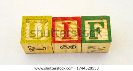 The term UIF unemployment insurance visually displayed on a clear background using colourful wooden toy blocks image with copy space in horizontal format