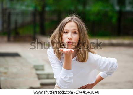 Portrait of a young beautiful blonde girl in white t-shirt - summer park outdoor background