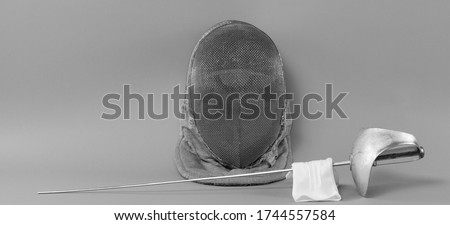 fencing helmet and fencing rapier isolated on gray background Royalty-Free Stock Photo #1744557584