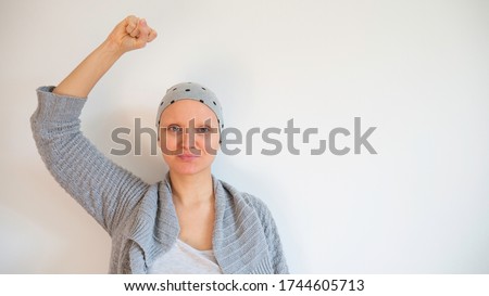 Portrait of female cancer survivor without eyebrows. Happy cancer survivor after successful chemotherapy.  Female hairless fight against cancer no white background. Negative space. Copy space for text Royalty-Free Stock Photo #1744605713