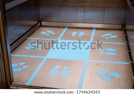 View of footprint sign for stand in lift. Social distancing with COVID-19 coronavirus.blue footprint sign.New normal ,Social distance, Social distancing the elevator (Lift) in hospital.