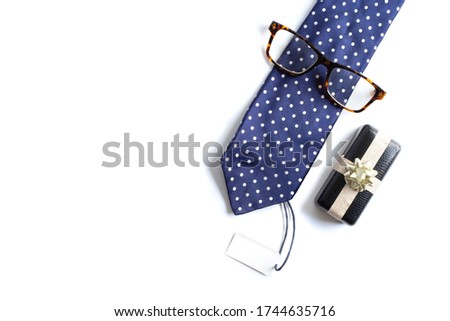 Blue tie, wrapped gift box, eyeglasses and gift tag on white background. Happy father's day, business present concept. Mock up, greeting card, symbol