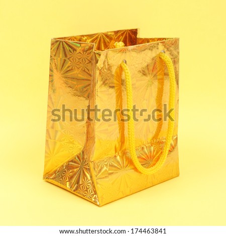 gold gift parcel over yellow background