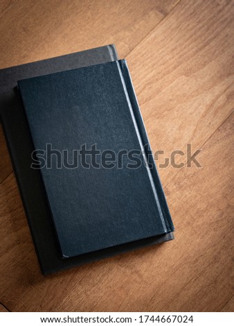 Two black notebooks on the brown maple wooden floor
