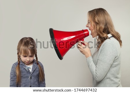 Child abuse concept. Parent abusing kid, mother shouting in loudspeaker to sad daughter Royalty-Free Stock Photo #1744697432