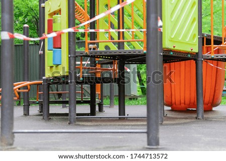 The play park for children is wrapped in red barrier tape. Prohibition of outdoor walks, prevention of the biological hazard of the coronavirus influenza virus. state of alarm. selective focus