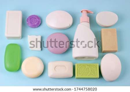 Hygiene and prevention of viral diseases concept.Various soap bar on blue background with blank bottle mock up.Set of soap different shape and color on baby blue backdrop. Top view Royalty-Free Stock Photo #1744758020