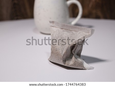 Unused coffee tea bag and white glass